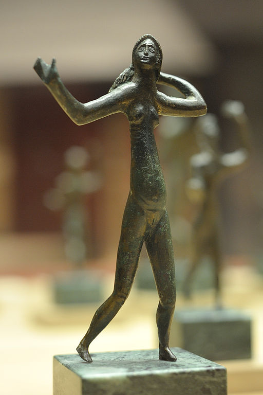 The bronze dancer from Neuvy-en-Sullias. Her torso and limbs are stretched to unnatural proportions. Her face looks up with stylized, almond shaped eyes. She steps forward with one leg and holds one arm out while the other is bent behind her head. The neo-Etruscan style makes it look like a Modern Art piece.